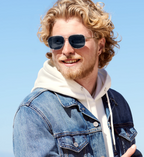 Bărbat poartă ochelari de soare Aviator cu Punte dubla, cu rame argintii și lentile negre, decor luminos de zi, purtând o jachetă jeans și hanorac alb.