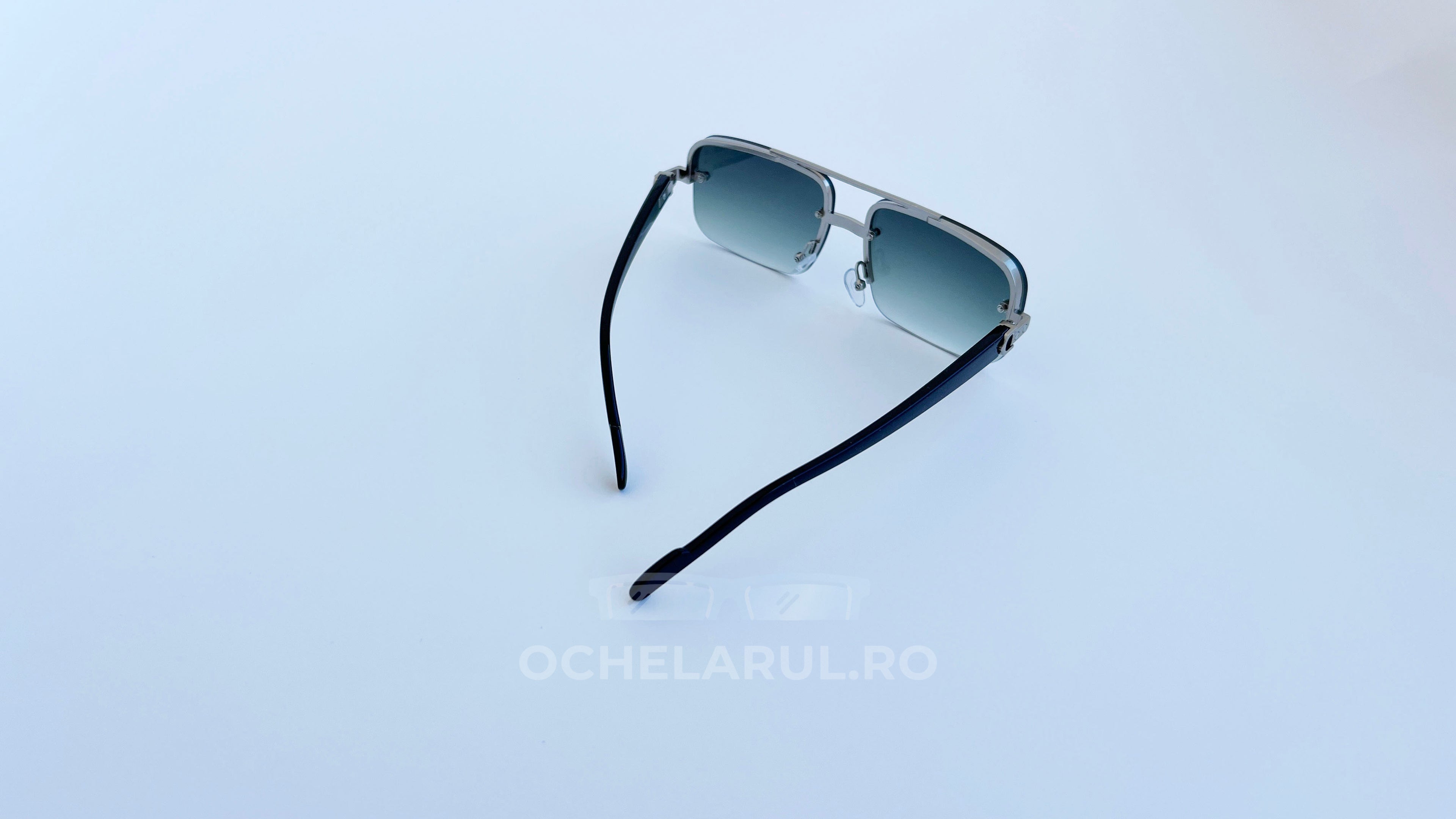 Ochelari de soare Dreptunghiulari cu rame argintii și lentile verzi pentru protecție UV.