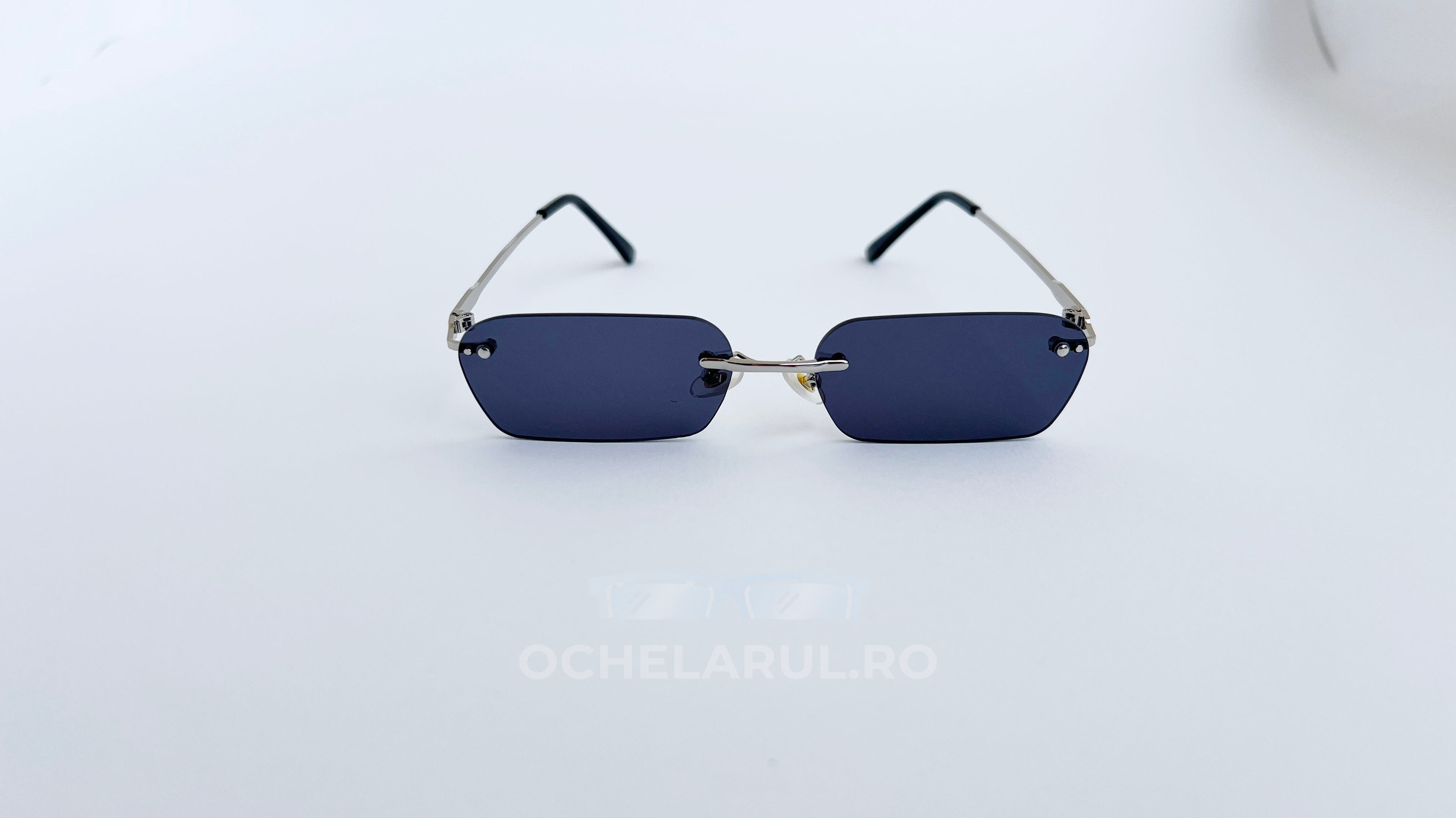 Ochelari de soare Dreptunghiulari Rimless cu lentile negre și rame subțiri argintii, model modern și minimalist.