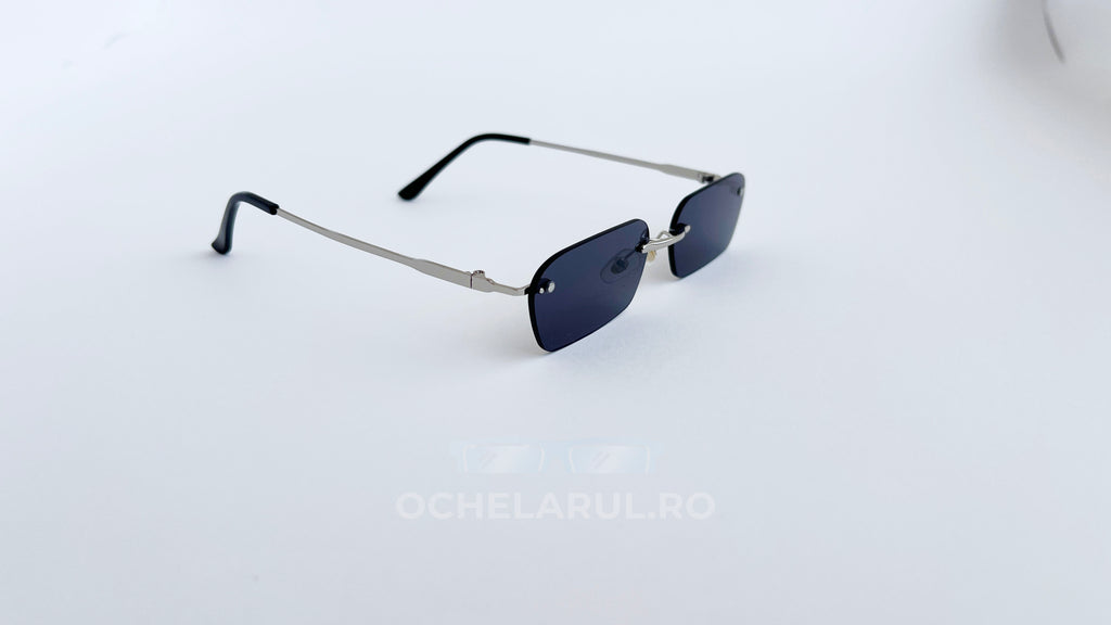 Ochelari de soare Dreptunghiulari Rimless cu lentile negre și brațe argintii, design minimalist și elegant.