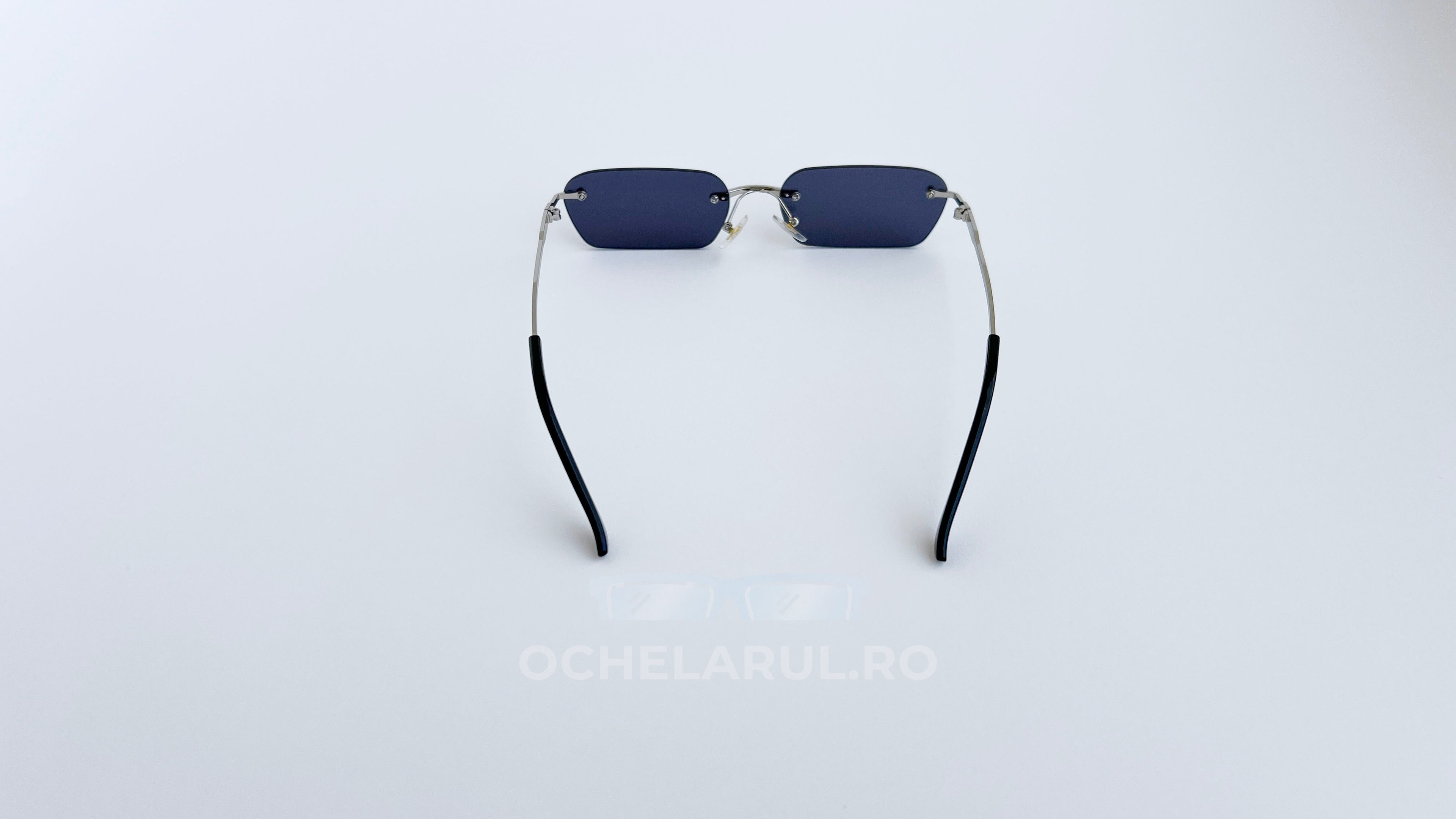 Ochelari de soare Dreptunghiulari Rimless cu lentile negre și brate argintii subțiri, design modern pentru bărbați.