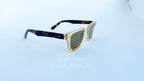 Ochelari de soare Moscot Klutz Style cu rame bej transparente și brațe cu model tortoise, lentile maro pentru o protecție stilată la soare.
