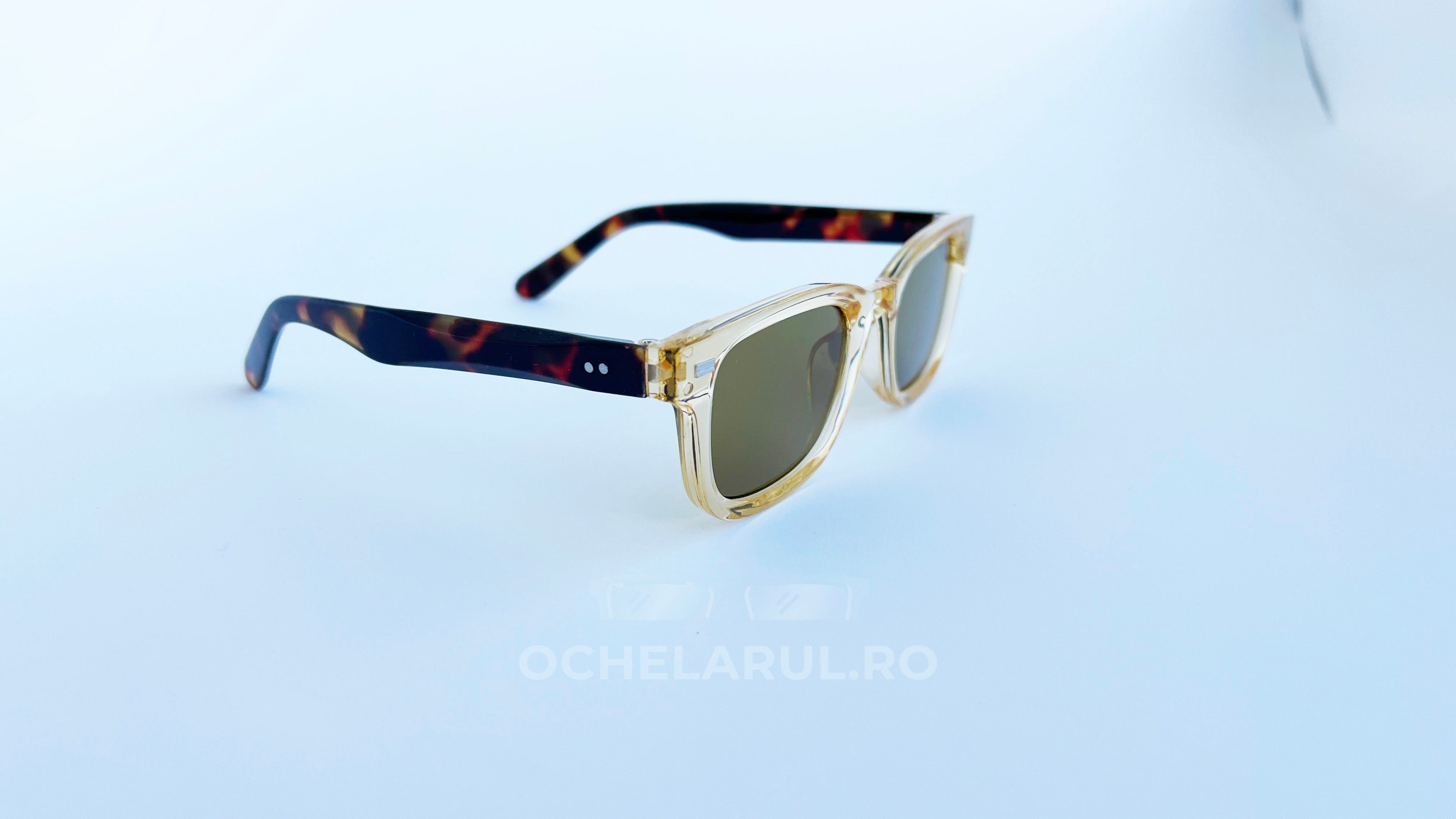 Ochelari de soare Moscot Klutz Style cu rame bej transparente și brațe cu model tortoise, lentile maro pentru o protecție stilată la soare.