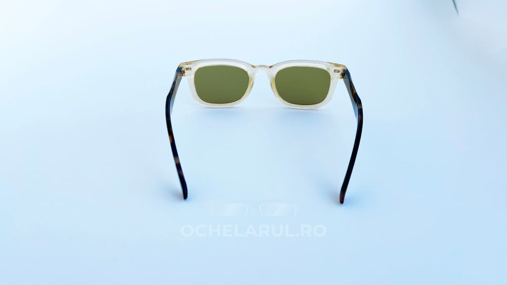 Ochelari de soare Moscot Klutz Style cu rame transparente bej și brațe în nuanțe de tortoise, lentile verzi, model unisex pentru protecție solară și stil modern.