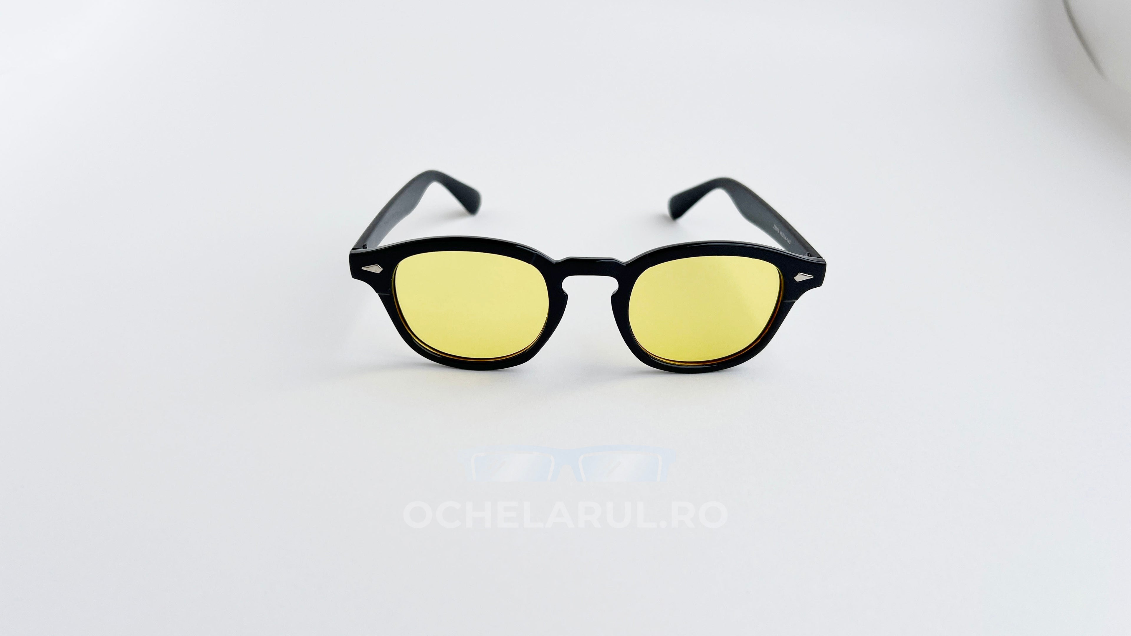 Ochelari de soare Moscot Lemtosh Style cu rame negre și lentile galbene, eleganți și moderni pentru bărbați.