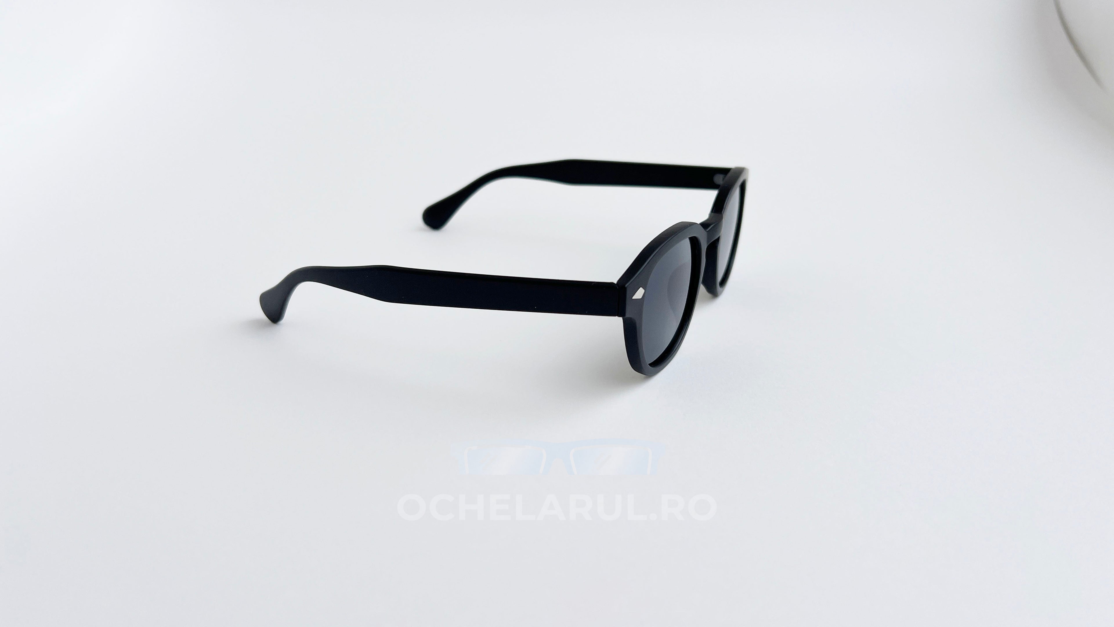 Ochelari de soare Moscot Lemtosh Style cu rame negre mate și lentile întunecate pentru protecție UV.