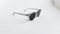 Ochelari de soare Oliver Peoples Style cu rame gri transparente și lentile gri, model pentru bărbați.