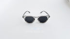 Ochelari de soare Oliver Peoples Style cu rame gri transparente și lentile gri închise pentru bărbați.