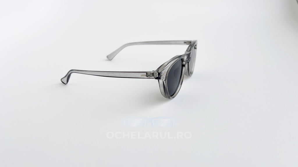 Ochelari de soare Oliver Peoples Style cu rame transparente gri și lentile gri, design modern pentru bărbați.
