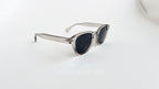 Ochelari de soare Moscot Lemtosh Style cu rame gri transparente și lentile negre pentru protecție UV.