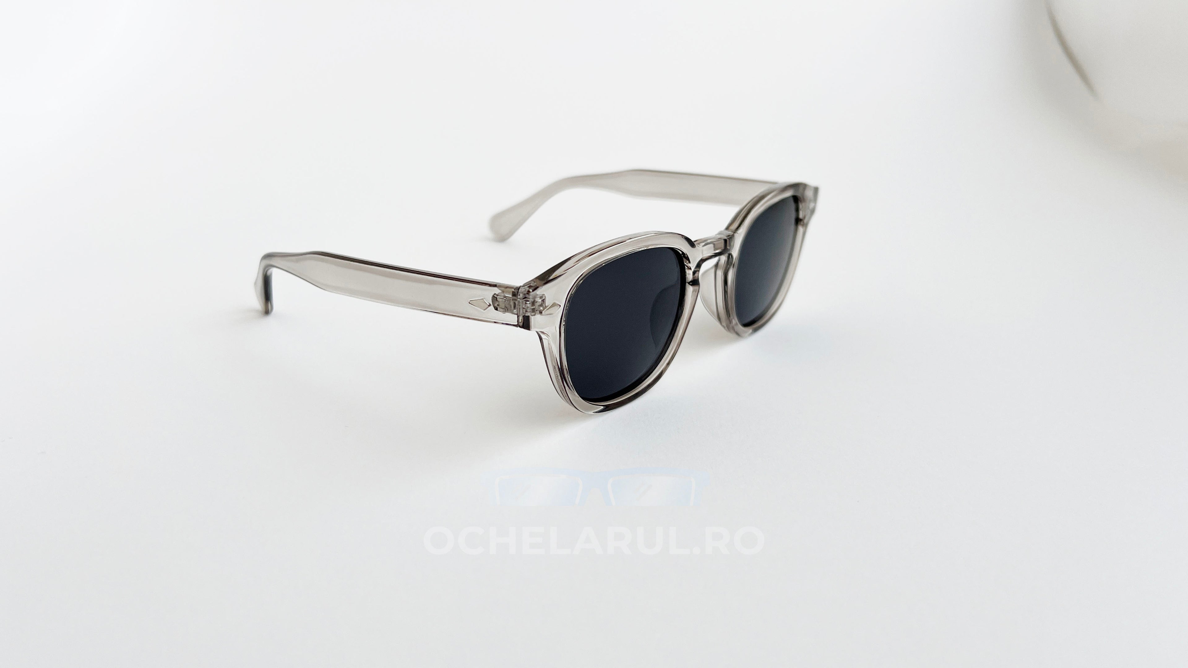 Ochelari de soare Moscot Lemtosh Style cu rame gri transparente și lentile negre pentru protecție UV.