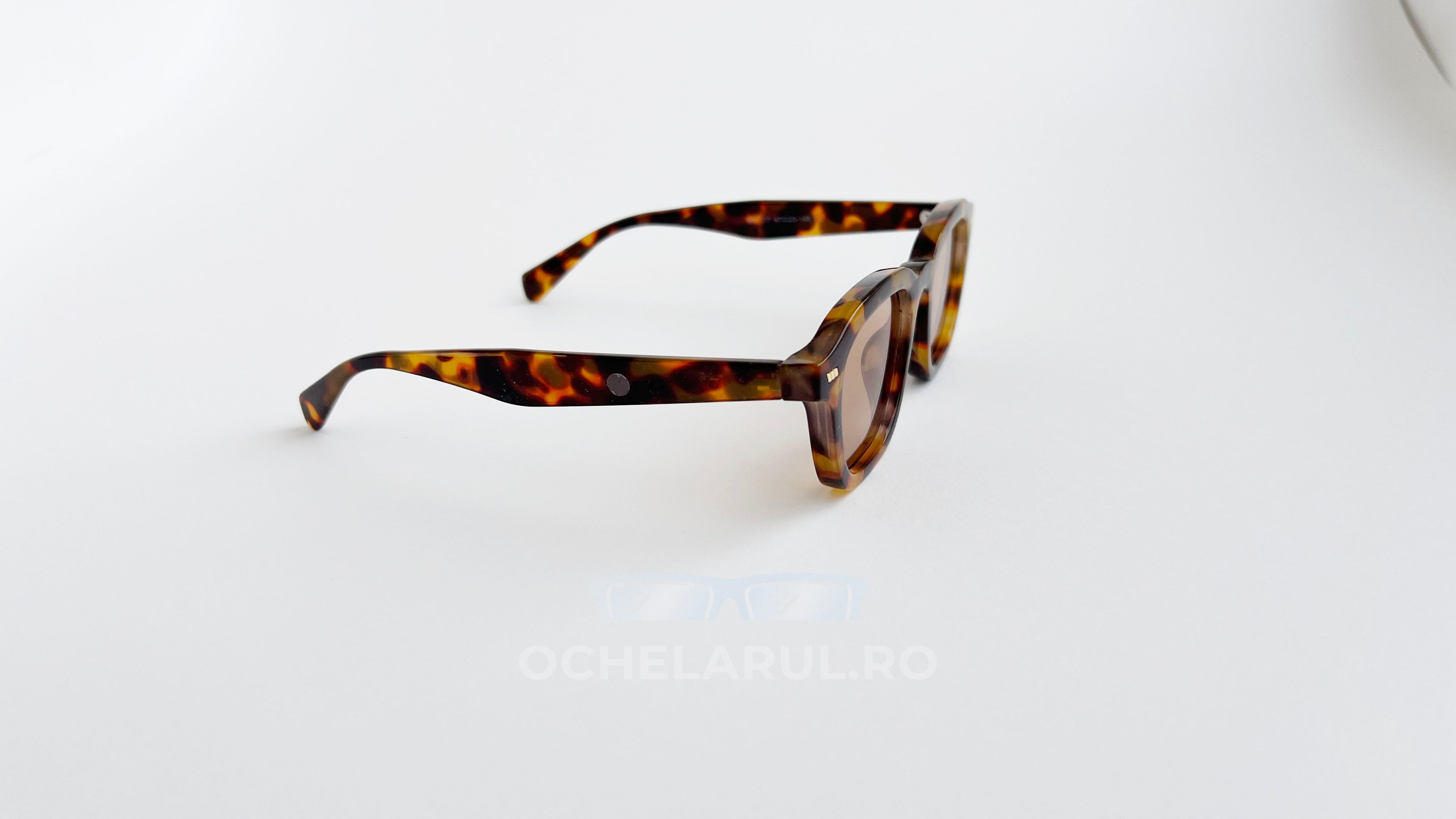 Ochelari de soare Tortoise cu rame de culoare maro în carapace de țestoasă și lentile în nuanțe calde, design unisex.