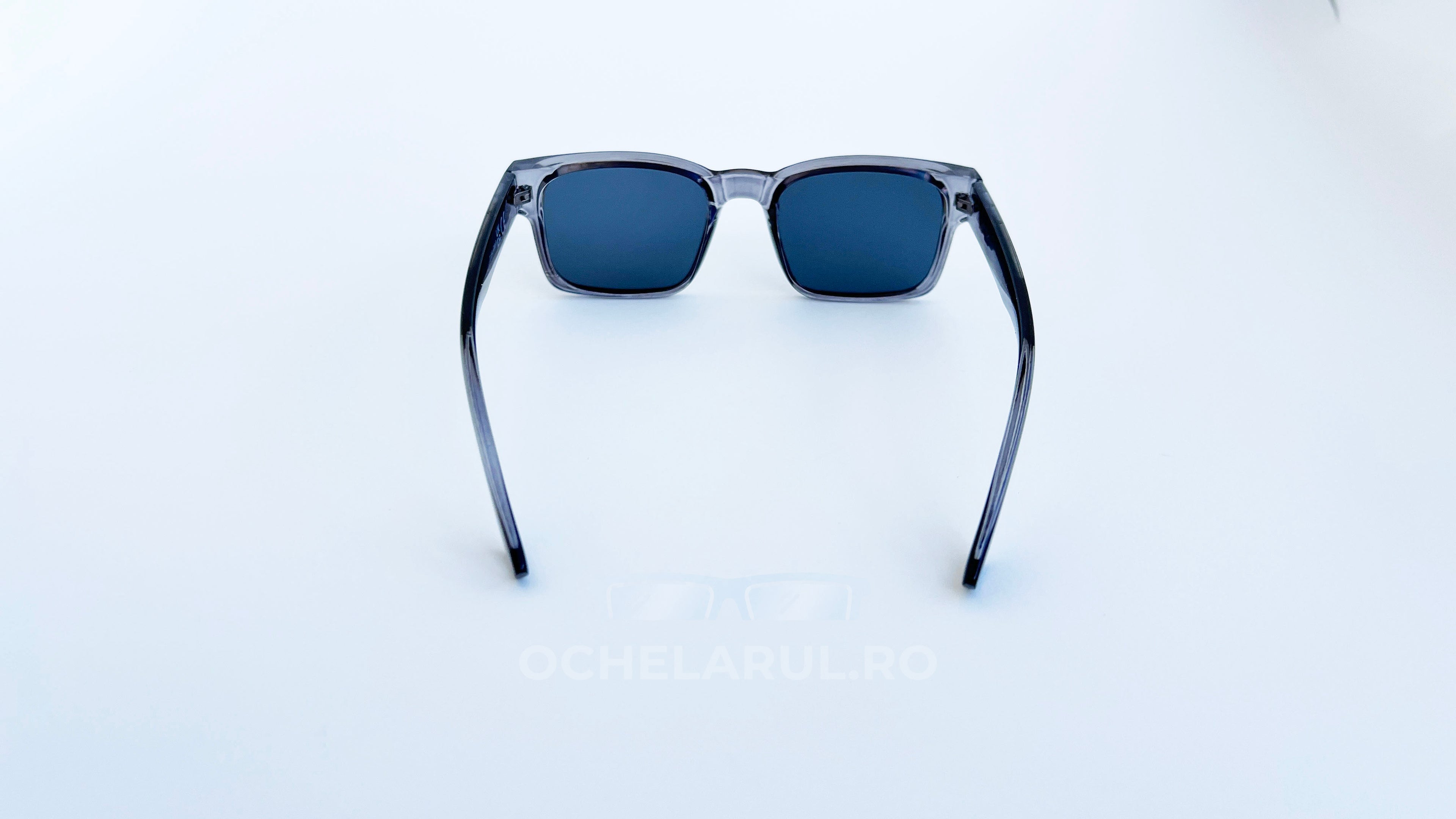 Ochelari de soare Retro Pătrați cu rame gri transparente și lentile negre, design modern și unisex, ideali pentru protecție solară și stil contemporan.