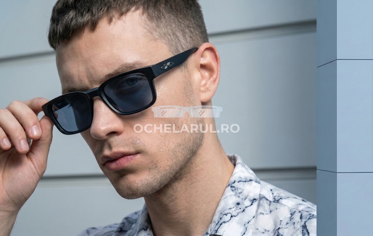 Bărbat purtând ochelari de soare Retro Pătrați cu ramă neagră și lentile închise la culoare, stil modern.
