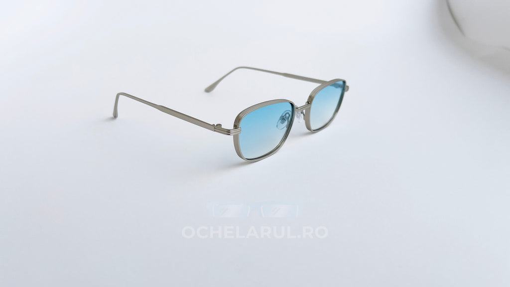 Ochelari de soare Retro Rectangulari cu rame argintii subțiri și lentile albastre degrade, design modern și elegant.