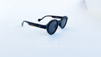 Ochelari de soare Rotunzi Retro Style cu rame negre și detalii tortoise, lentile negre, design retro pentru un look sofisticat și protecție solară optimă.