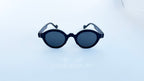 Ochelari de soare Rotunzi Retro Style cu rame negre elegante și lentile întunecate, model unisex potrivit pentru protecție și stil casual modern.