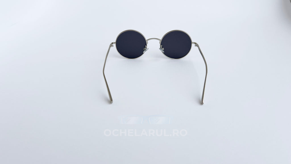 Ochelari de soare Rotunzi cu rame argintii subțiri și lentile negre, design clasic și elegant.