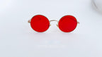 Ochelari de soare Rotunzi cu rame aurii și lentile roșii, design elegant și modern pentru protecție solară și stil distinct.