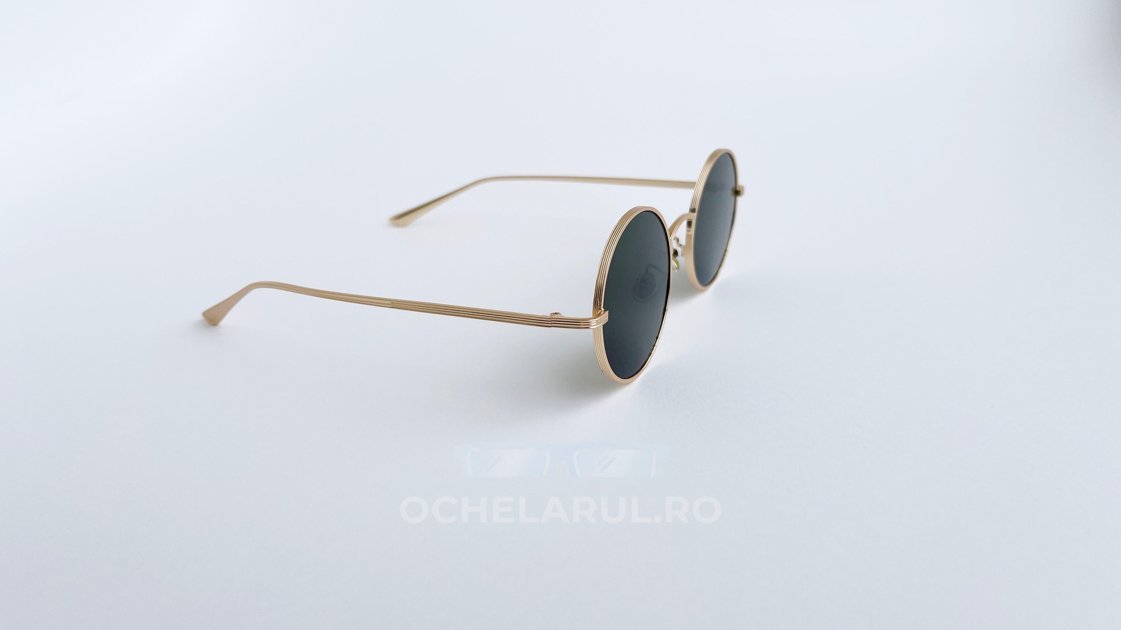 Ochelari de soare Rotunzi cu rame aurii subțiri și lentile închise la culoare, design minimalist pentru bărbați.
