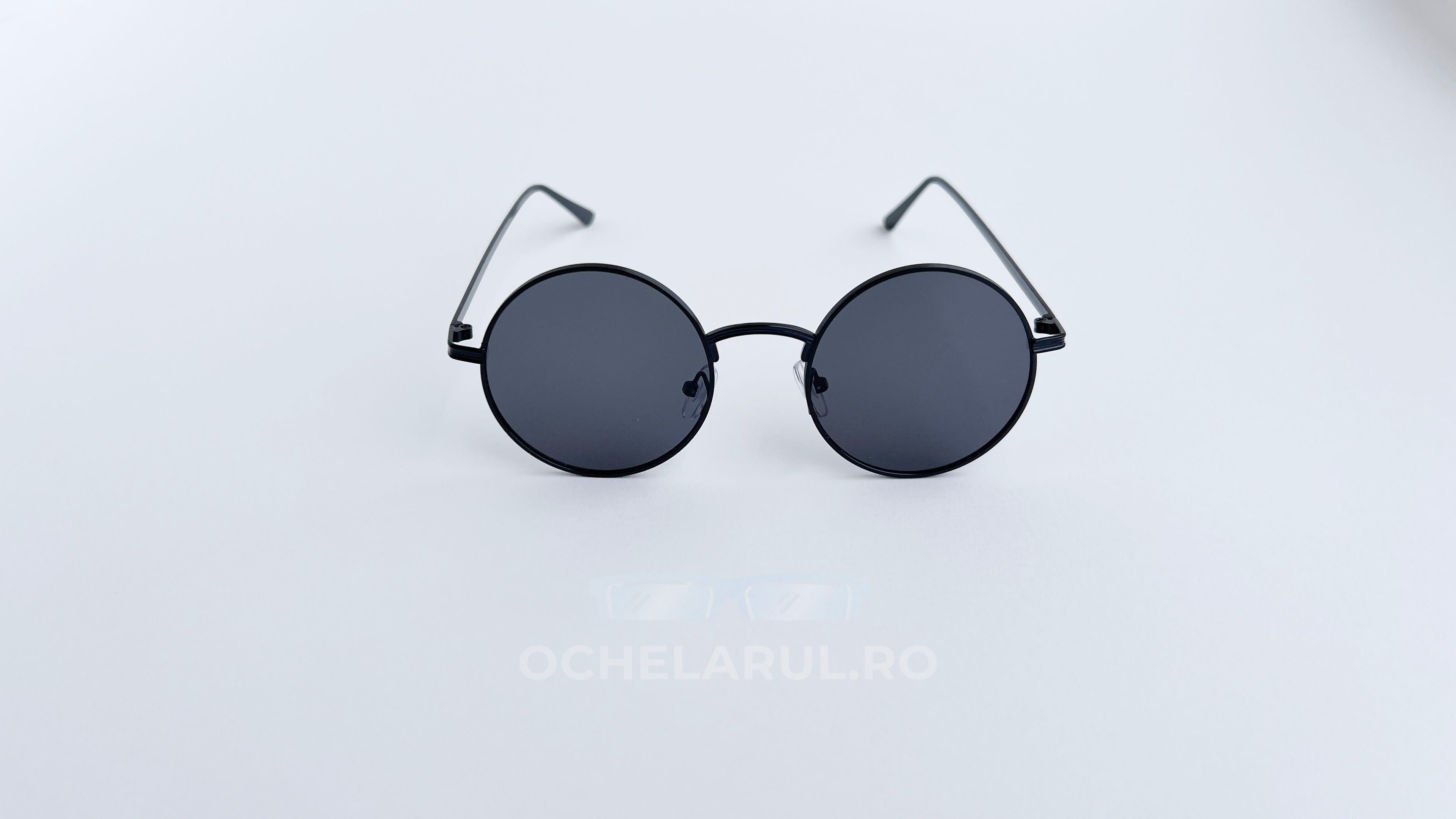 Ochelari de soare Rotunzi cu rame negre subțiri și lentile întunecate, design clasic și elegant.