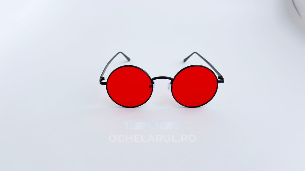 Ochelari de soare Rotunzi cu ramă neagră subțire și lentile roșii intense, design modern și distinctiv.