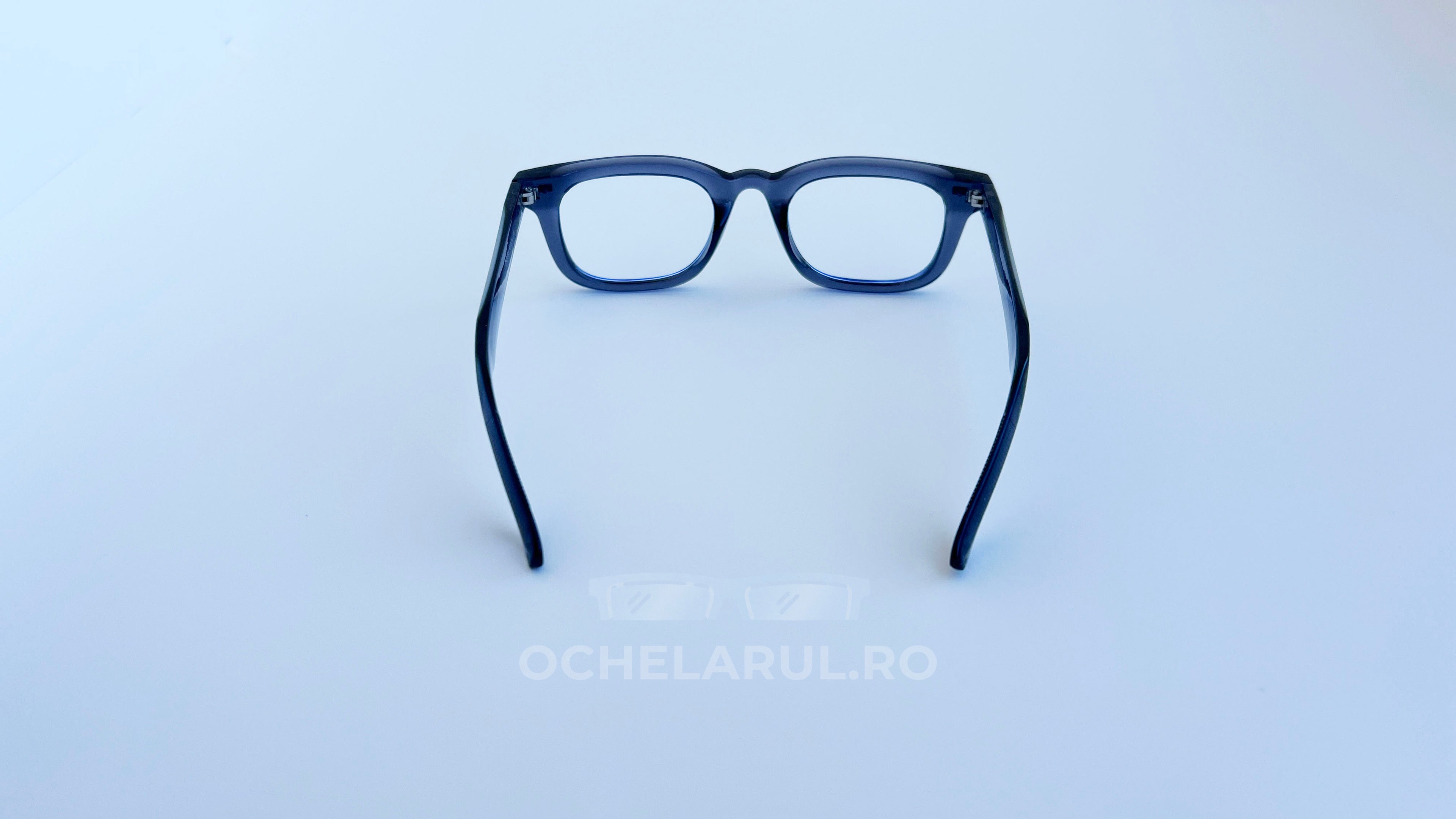 Rame ochelari Moscot Klutz Style negre, cu design dreptunghiular și lentile transparente, prezentate pe fundal alb.