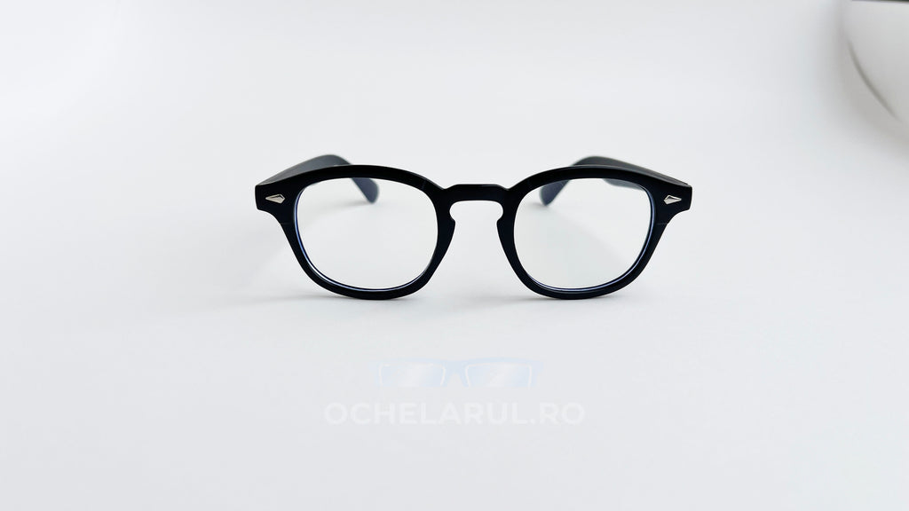 Rame ochelari Moscot Lemtosh Style negre cu lentile transparente așezate pe fundal alb simplu.