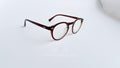 Rame ochelari Oliver Peoples Style cu lentile transparente și finisaj maro degrade, design elegant și modern.