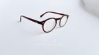 Rame ochelari Oliver Peoples Style cu lentile transparente și finisaj maro degrade, design elegant și modern.