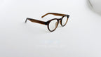 Rame ochelari Ovale Retro maro, cu lentile transparente și design clasic, pe fundal alb simplu.