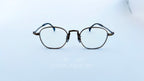Rame ochelari Pătrați din Titan Vintage Style cu cadru bronz, design pătrat vintage și lentile transparente pentru un aspect elegant și durabil.
