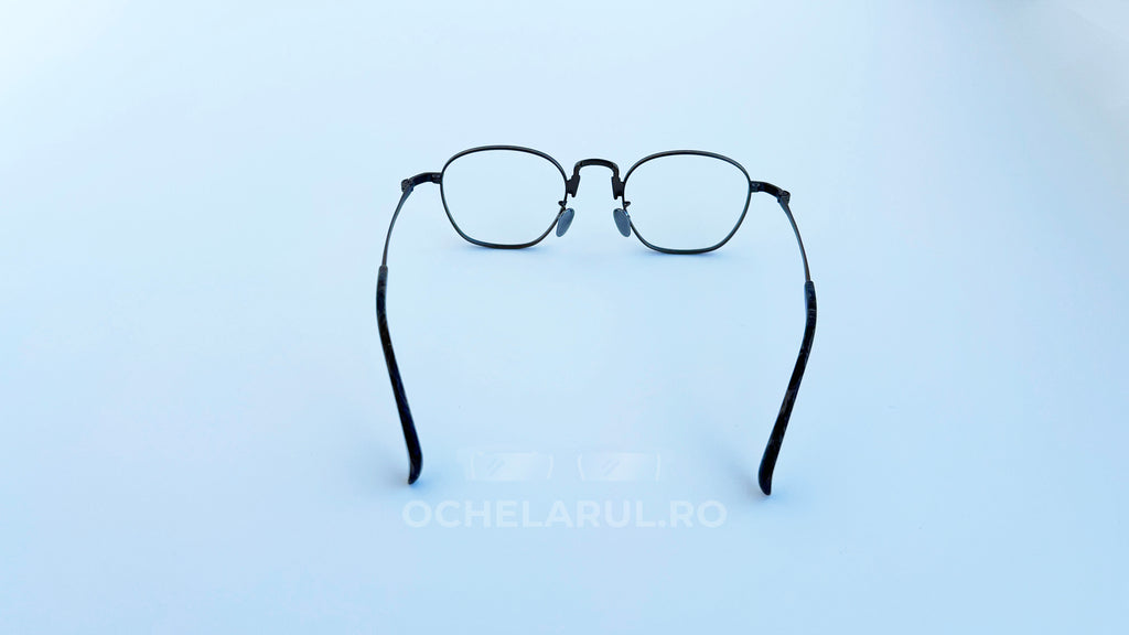 Rame ochelari Pătrați din Titan Vintage Style cu lentile transparente, design minimalist, cadru subțire din titan de culoare bronz, văzute din spate pe fundal alb.