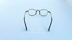 Rame ochelari Pătrați din Titan Vintage Style cu lentile transparente, design minimalist, cadru subțire din titan de culoare bronz, văzute din spate pe fundal alb.